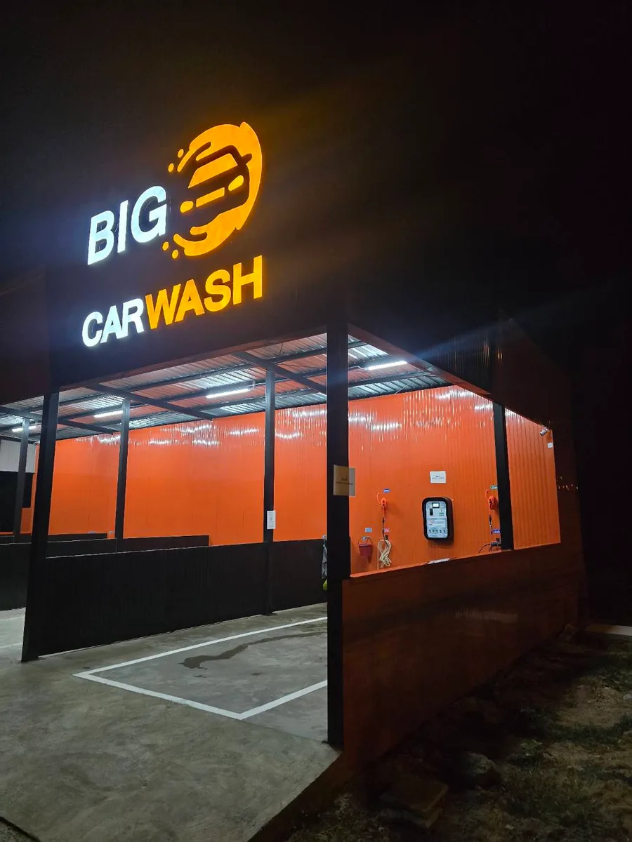 ร้าน BIG-O Carwash ผนังส้ม โครงเหล็กดำ และช่องล้างรถ